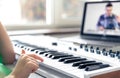 A girl learns to play the piano with a teacher online, remote learning music. Royalty Free Stock Photo