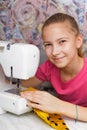 Girl learns to sew on an sewing machine Royalty Free Stock Photo