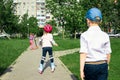 The girl learns to skate on the street. Children wear protective pads and a protective helmet for safe riding on rollers. Active