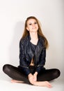 Girl in a leather jacket leather shorts is based on a stepladder Royalty Free Stock Photo