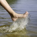 Girl legs in the river water close up. Summer banner Close up of a young girls legs walking or running on the beach with Royalty Free Stock Photo