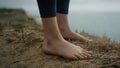 Girl legs standing hilltop closeup. Unknown barefoot woman relaxing on sea beach Royalty Free Stock Photo