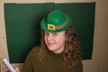 girl in a leprechaun hat on a green background Royalty Free Stock Photo