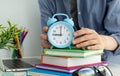 The girl in the library with books in hand alarm clock, time to learn, time education