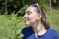 Girl licking stinging nettle leaves Royalty Free Stock Photo
