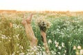 A girl lies in a chamomile field with her legs raised and a bouquet of daisies. Sunset Royalty Free Stock Photo