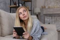 The girl lies on the couch and reads a tablet. Comfortably working remotely at home. Copy space Royalty Free Stock Photo