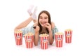 Girl lies on the floor with buckets of popcorn.. Isolated on white Royalty Free Stock Photo