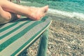 The girl lies with her feet on a sunbed made of fabric. sunbathing under the bright sun by the sea. woman relaxing on the sea near Royalty Free Stock Photo