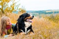 girl lies next to big dog on autumn walk