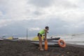 Girl lifeguard on duty keeping a buoy at the beach. Water scooter, Lifeguard rescue equipment orange preserver tool on beach. Safe