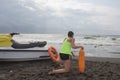 Girl lifeguard on duty keeping a buoy at the beach. Water scooter, lifeguard rescue equipment orange preserver tool on beach. Saf