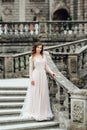 A girl in a light pink dress against the background of a medieva castle