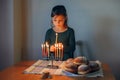 Girl lighting candles on menorah for traditional Jewish Hanukkah holiday at home. Child celebrating Chanukah, festival of lights. Royalty Free Stock Photo