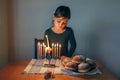 Girl lighting candles on menorah for traditional winter Jewish Hanukkah holiday at home. Child celebrating Chanukah festival of Royalty Free Stock Photo