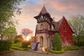 A girl in a lilac dress standing at the door of a beautiful art Nouveau cottage in the autumn garden