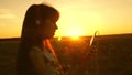 Girl listening to music and dancing in the rays of a beautiful sunset. a young girl in headphones and with a smartphone