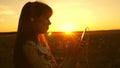 Girl listening to music and dancing in the rays of a beautiful sunset. a young girl in headphones and with a smartphone