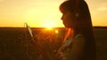 Girl listening to music and dancing in the rays of a beautiful sunset. a young girl in headphones and with a smartphone