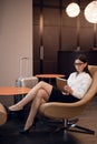 Girl listening to music through headphones on the tablet at business lounge at the airport.