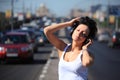 Girl listens music in ear-phones on highway middle