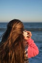 a girl listens to a seashell on the beach Royalty Free Stock Photo