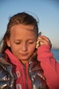 a girl listens to a seashell on the beach Royalty Free Stock Photo