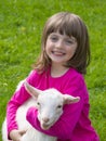 Girl and little goat sitting on a meadow Royalty Free Stock Photo