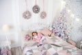 Girl little kid relaxing on bed light interior with christmas decorations. Christmas eve concept. Child waiting Royalty Free Stock Photo