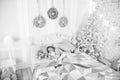 Girl little kid relaxing on bed light interior with christmas decorations. Christmas eve concept. Child waiting Royalty Free Stock Photo