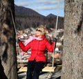 Girl on a log rope swing, city background Royalty Free Stock Photo