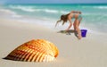 Girl by Lone Seashell on Beach