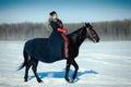 A girl in a long black dress with a dark horse Royalty Free Stock Photo