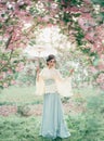 A girl with long, black hair decorated with Kandzashi, flowers and long pins with crystal beads. Geisha in a bamboo