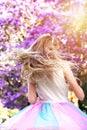 A girl with a long blond hair near the jacaranda tree in a full bloom with beautiful purple flowers Royalty Free Stock Photo