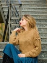 Girl long blond hair relax on stairs. girl in corrugated skirt and sweater. Pleated trend. casual style student girl