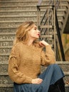 girl long blond hair relax on stairs. girl in corrugated skirt and sweater. Pleated trend. casual style student girl