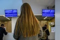 Girl with long blond hair waiting for the registration of flight to Moscow at Chisinau airport. Back view