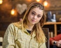 Girl with long blond straight shining hair posing indoors. Beautiful teenage model wearing boyish oversize shirt. Female Royalty Free Stock Photo