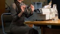 A girl with a long braid is typing on an old vintage typewriter Royalty Free Stock Photo