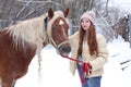 girl with long brown hair and chestnut horse with plaited mane close up portrait on winter snowy background