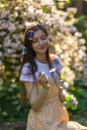 A girl with long brunette hair blows bubbles blower in the summer on a green meadow on a sunny day Royalty Free Stock Photo