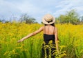 Girl with long dark hair in a hat among yellow flowers Royalty Free Stock Photo