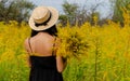 Girl with long dark hair in a hat among yellow flowers Royalty Free Stock Photo