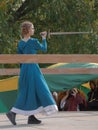 A girl in a long dress demonstrates her sword skills