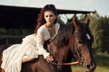 Girl in a long dress riding a horse, a beautiful woman riding a horse in a field in autumn. Country life and fashion, noble steed Royalty Free Stock Photo