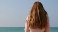 Girl with long ginger red hair enjoying seascape. Sea breeze playing with hair Royalty Free Stock Photo