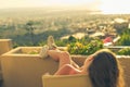 Girl with a long hair on the chair on the balcony on the sunset background