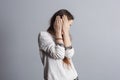 Girl with long hair covers face with hands. Royalty Free Stock Photo