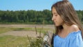 Girl with long hair in a field looking at the camera